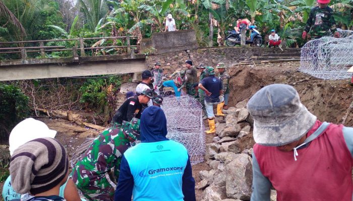 Gotong Royong Warga Desa Kalempang dan Anggota Satgas TMMD Memperkuat Talud Sungai Kalempang dengan Pemasangan Batu Baronjong