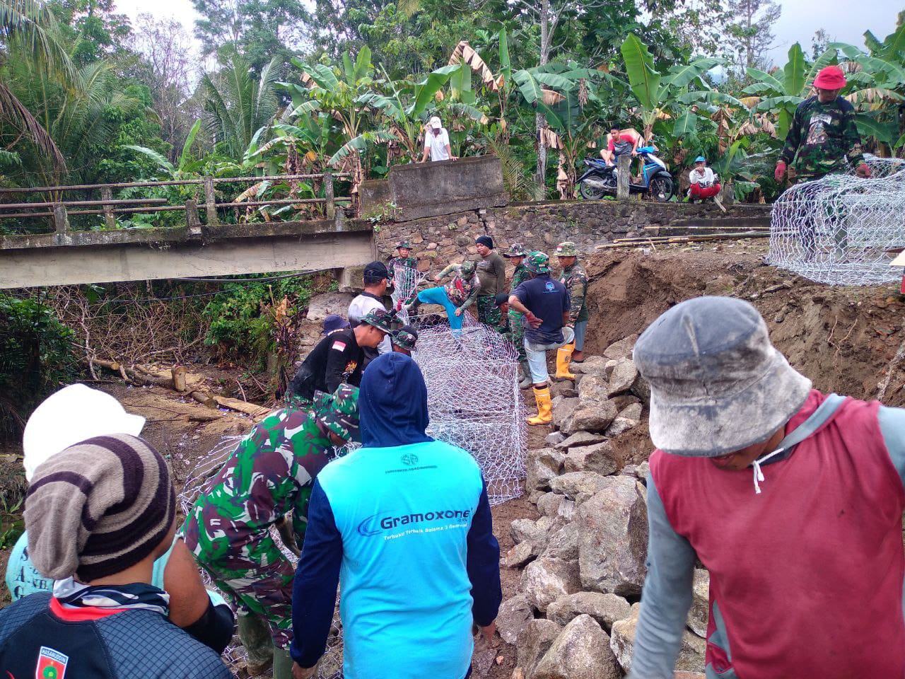 Gotong Royong Warga Desa Kalempang dan Anggota Satgas TMMD Memperkuat Talud Sungai Kalempang dengan Pemasangan Batu Baronjong