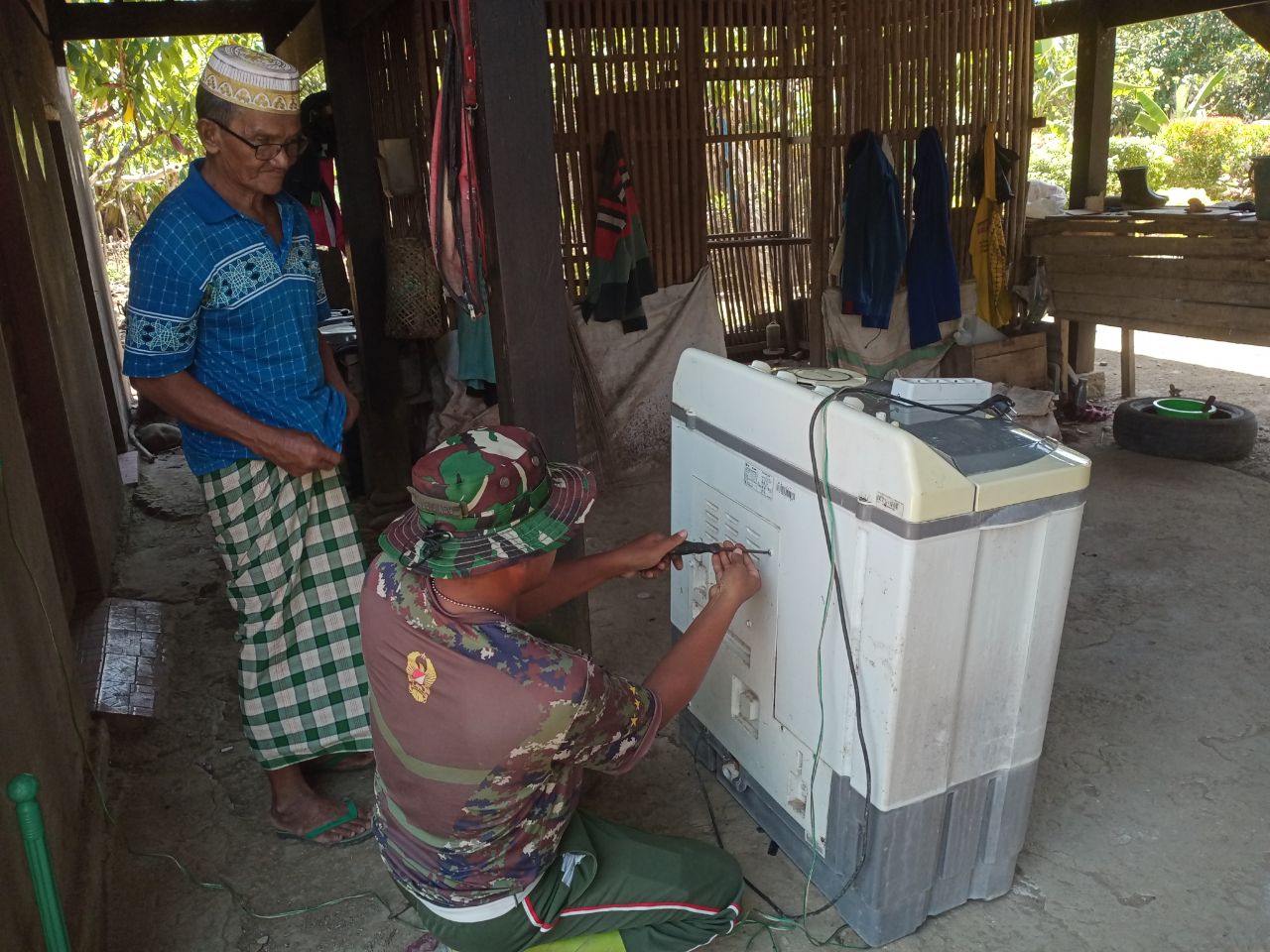 Anggota Satgas TMMD Kodim 1420/Sidrap Bantu Perbaiki Mesin Cuci Warga Desa Kalempang