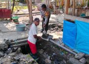 Bhabinkamtibmas Polres Majene Bantu Warga Perbaiki Saluran Drainase di Desa Kayuangin