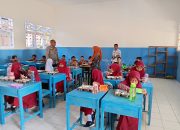 Bhabinkamtibmas Polsek malunda Kawal Penyaluran Makanan Bergizi Gratis untuk Siswa SD Negeri 03 Mosso